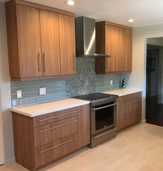 A kitchen with wooden cabinets , stainless steel appliances , and a stove.