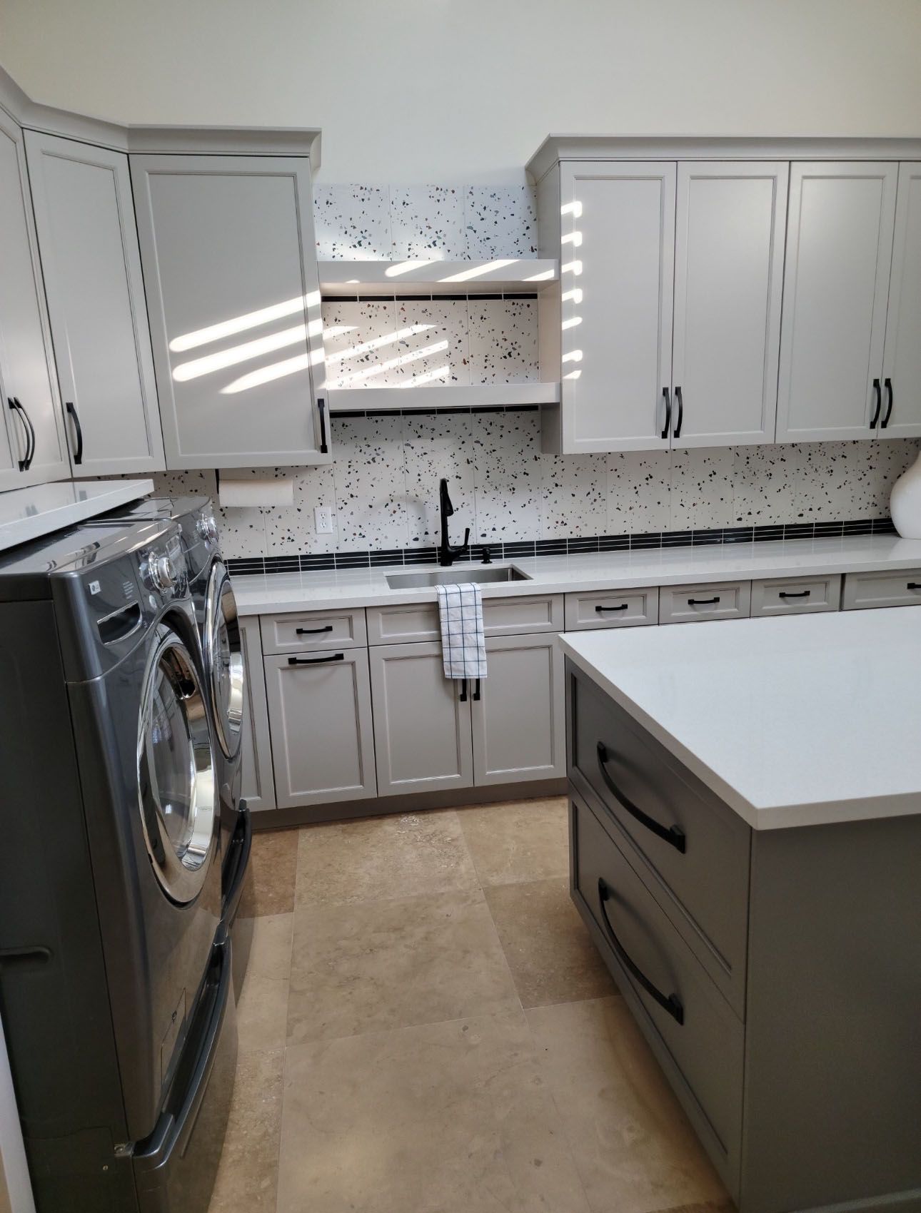 A kitchen with a washer and dryer and a sink