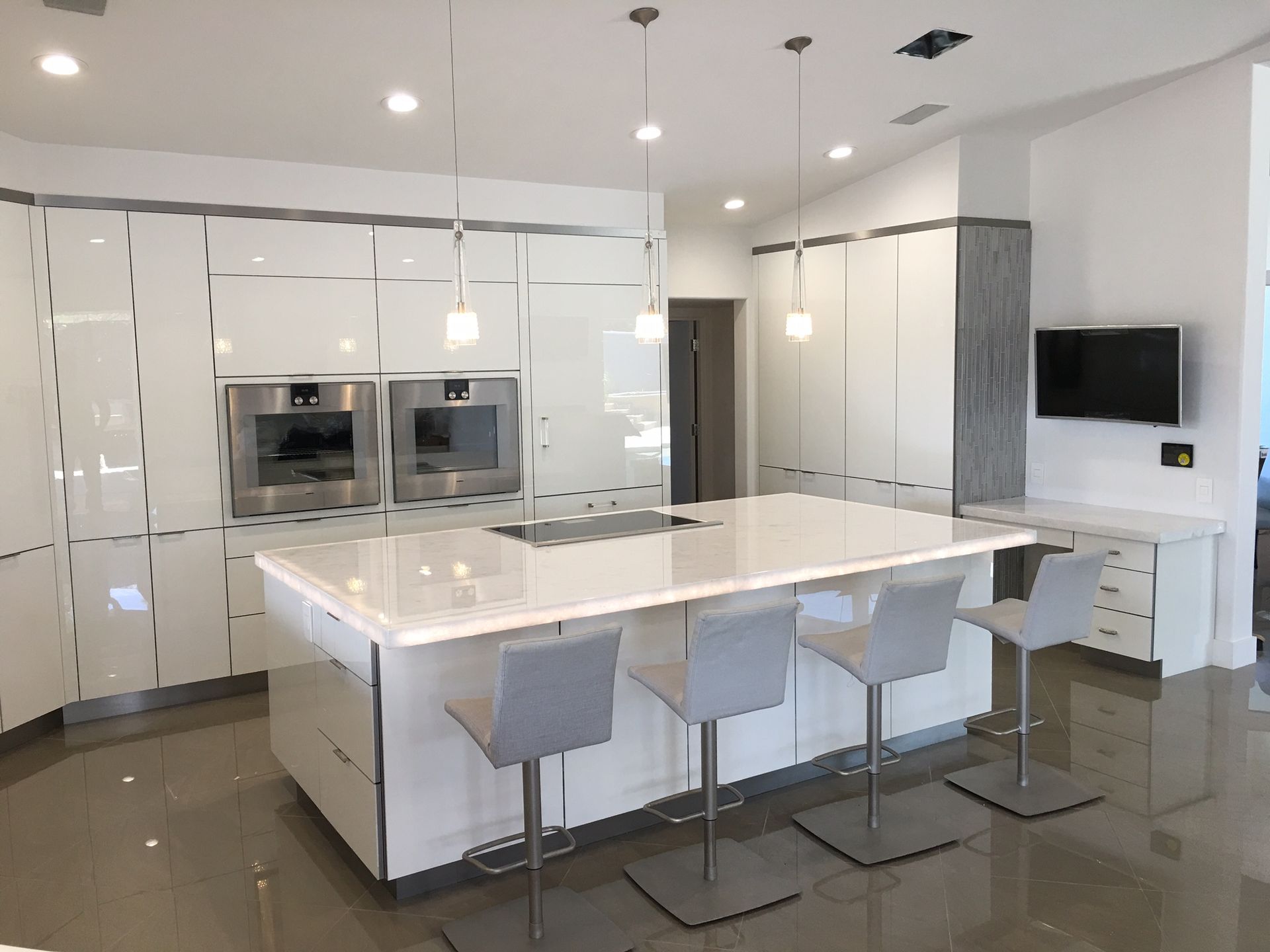 A kitchen with white cabinets and a large island