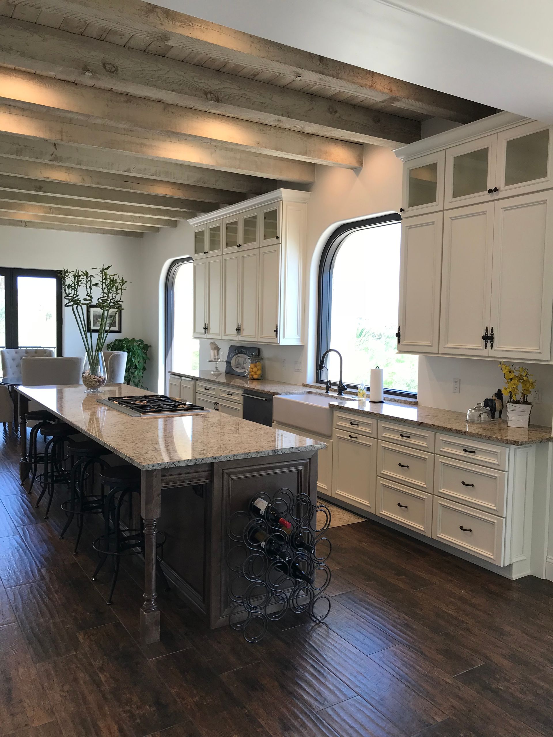 A kitchen with white cabinets , granite counter tops , and a large island.