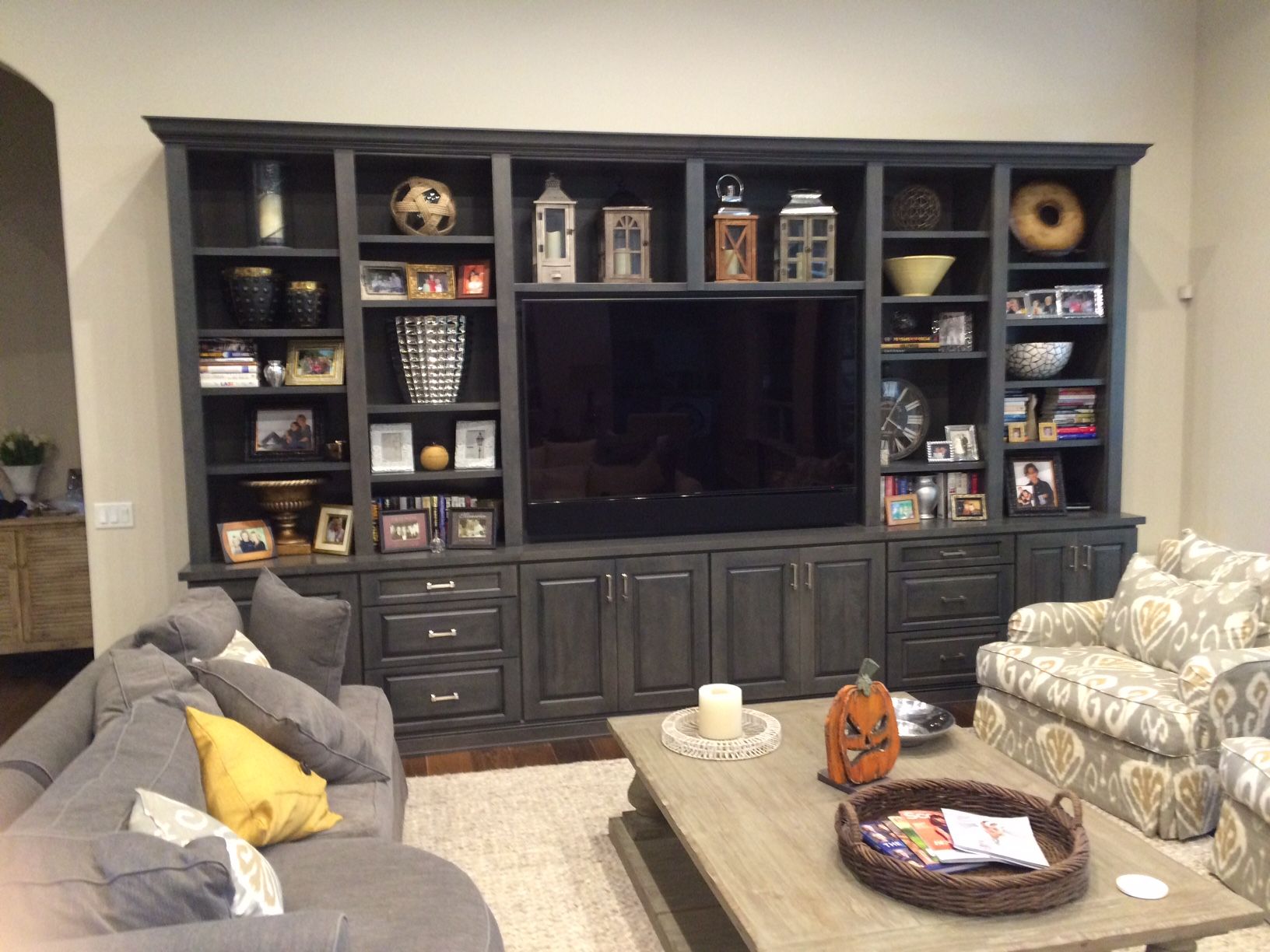 A living room with a large entertainment center and a flat screen tv