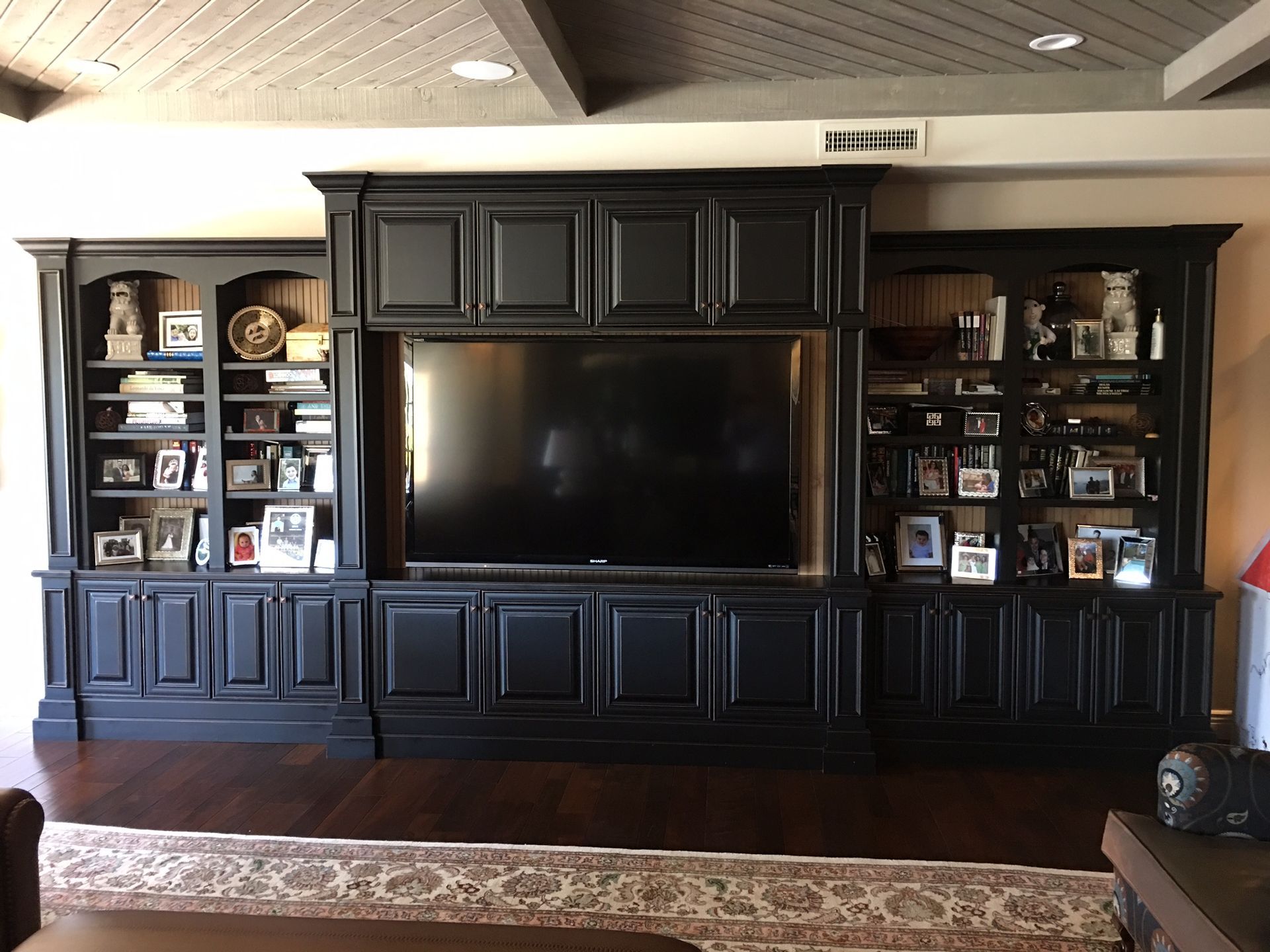 A living room with black cabinets and a flat screen tv
