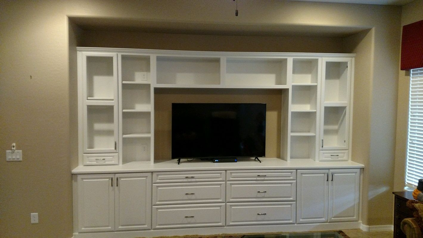 A living room with white cabinets and a flat screen tv