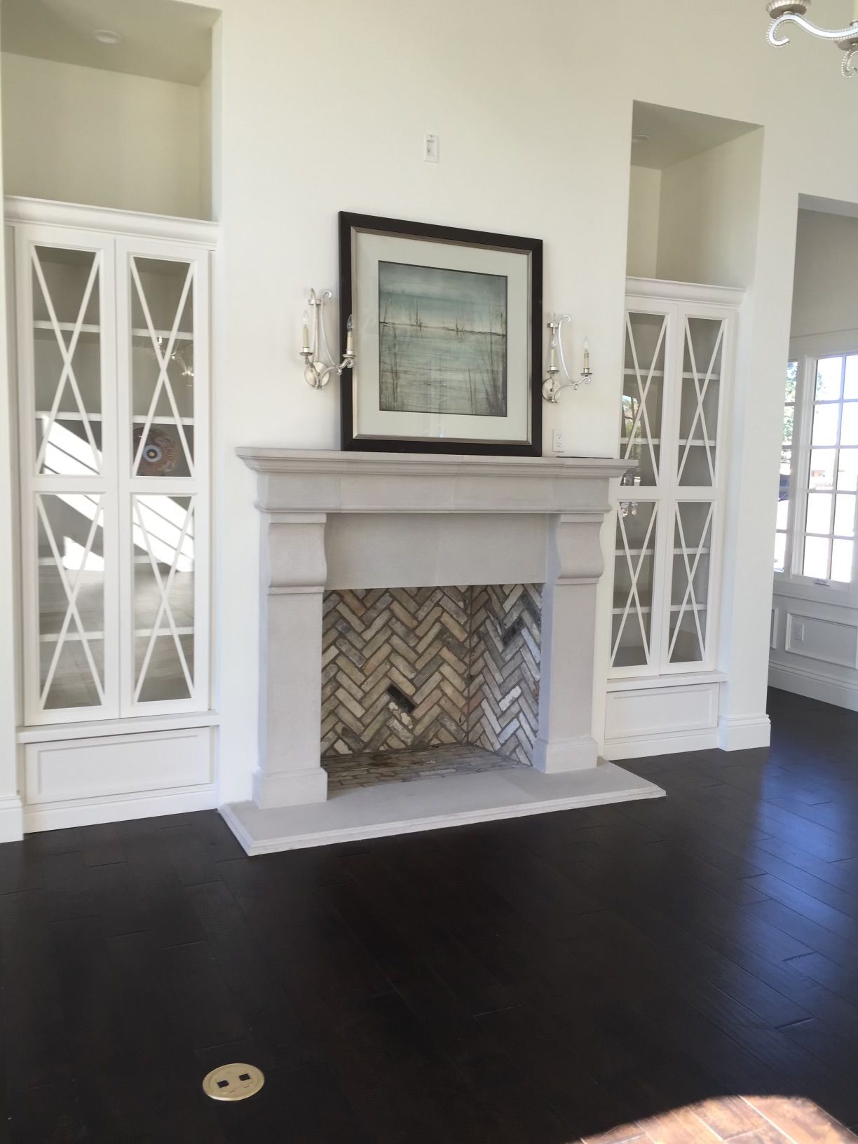 A living room with a fireplace and a picture on the mantle.