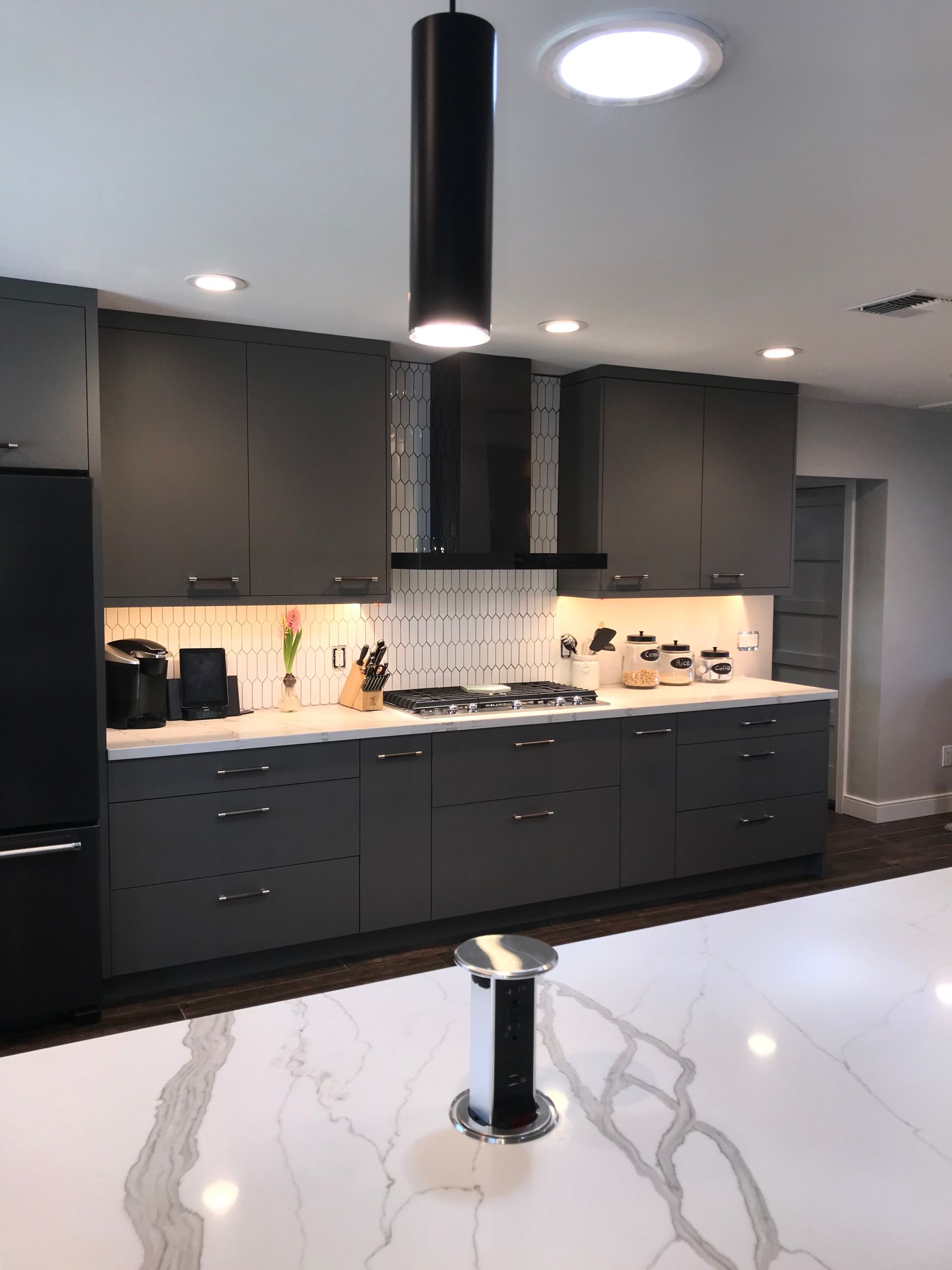 A kitchen with black cabinets and white counter tops