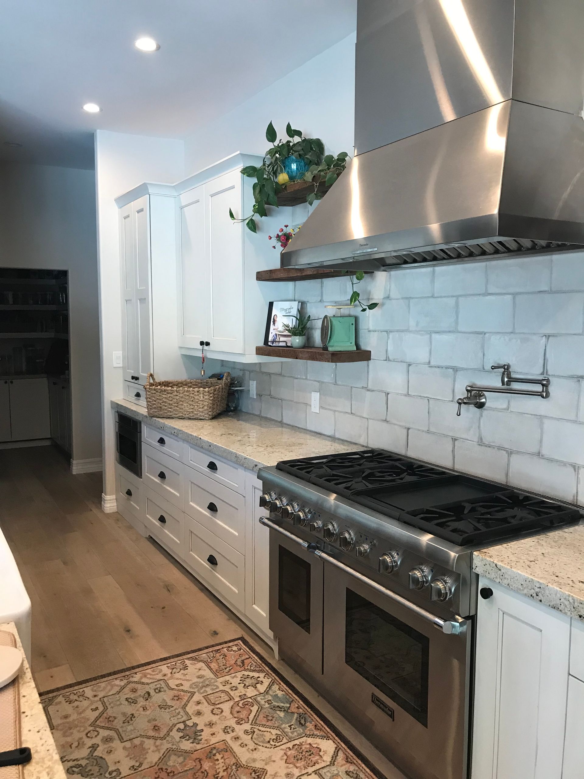 A kitchen with stainless steel appliances and white cabinets