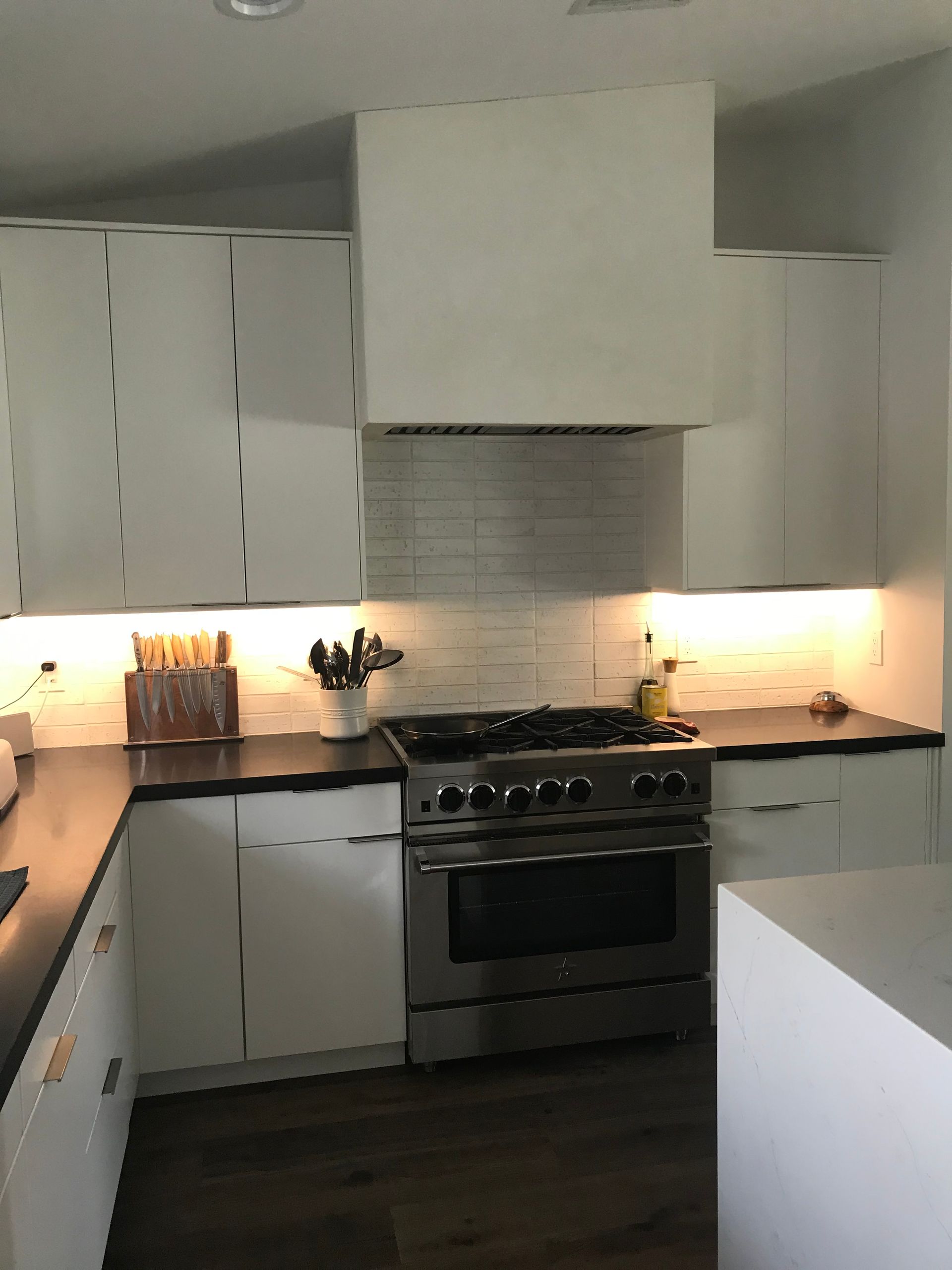 A kitchen with stainless steel appliances and white cabinets