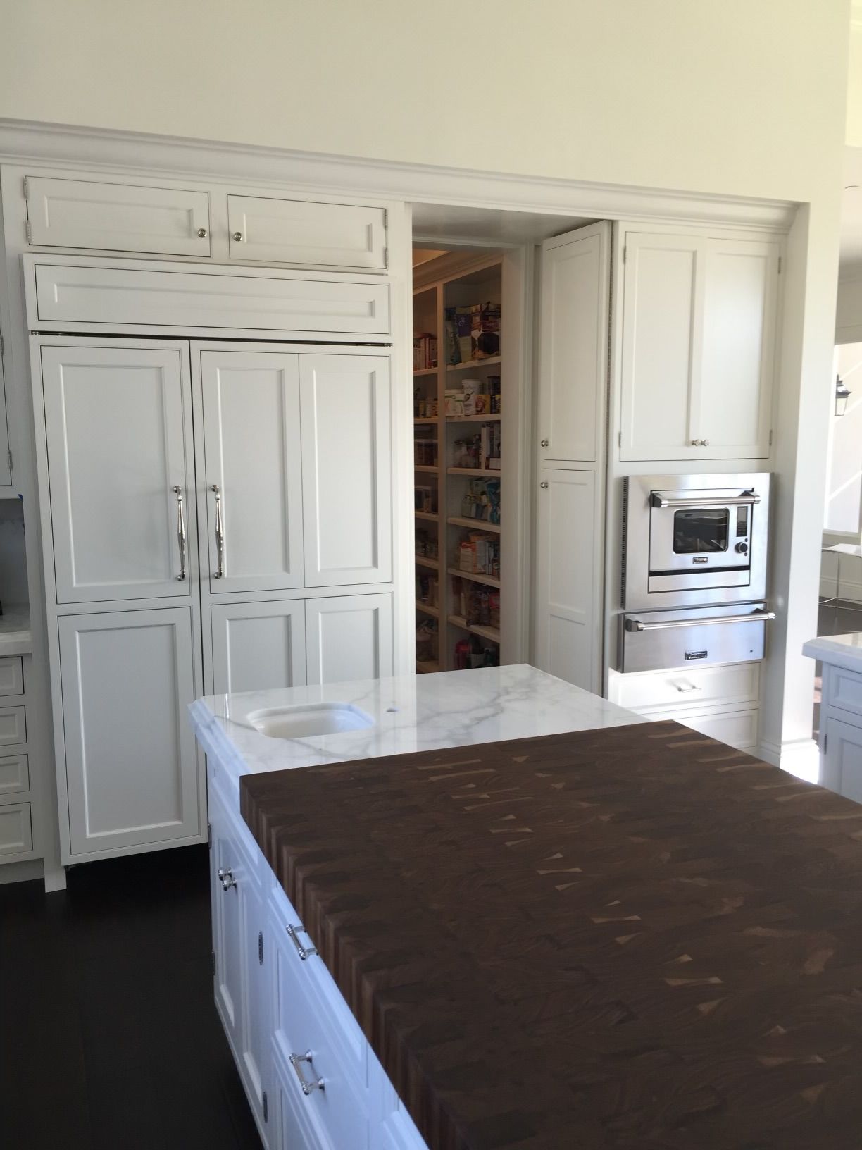 A kitchen with white cabinets and a brown counter top