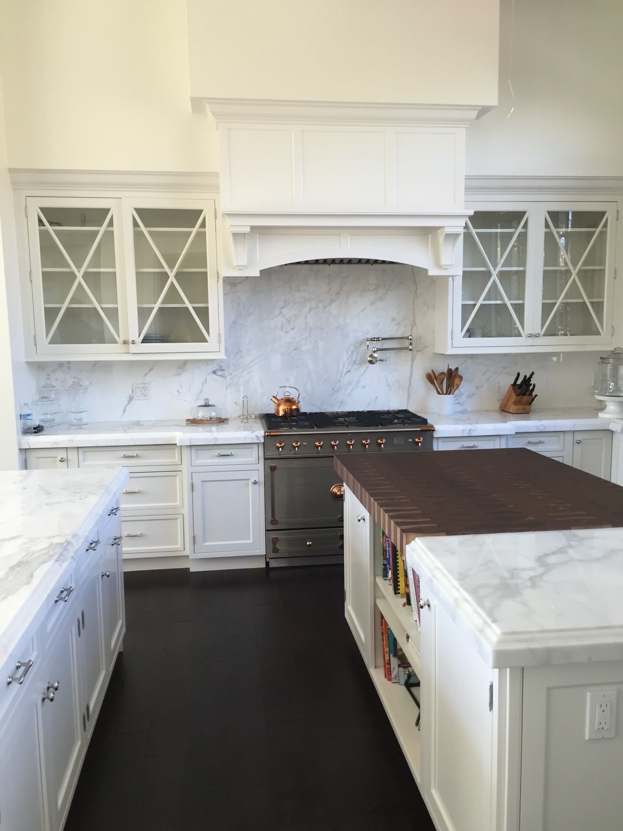 A kitchen with white cabinets and a large island in the middle