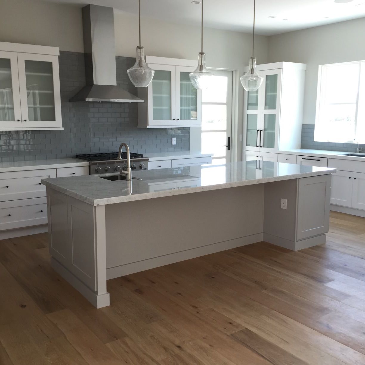 A kitchen with white cabinets and a large island