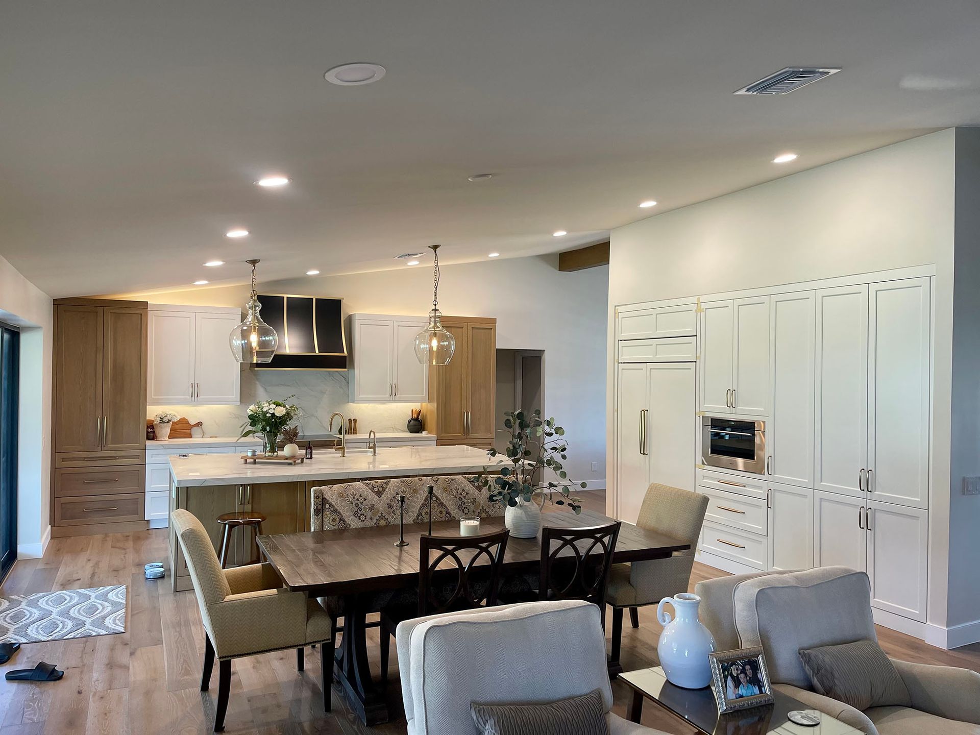 A living room with a dining table and chairs and a kitchen.