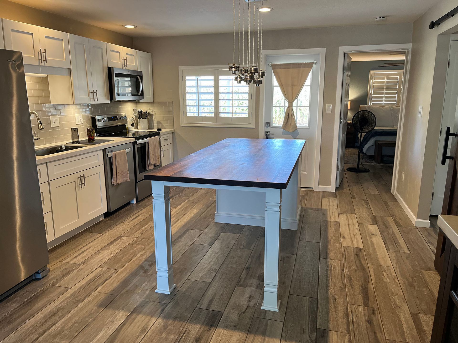 A kitchen with a large wooden table in the middle of it.