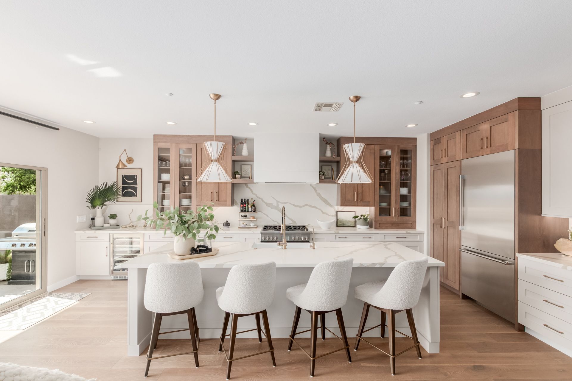 A kitchen with white cabinets and stainless steel appliances and a large island.
