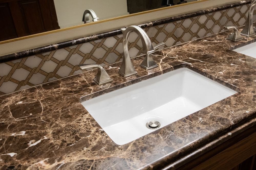 Brown marble countertop with a white sink and silver faucet in a bathroom.