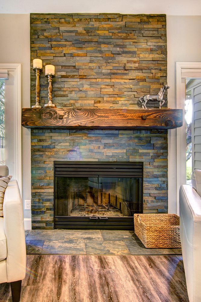 Fireplace with stone surround, wooden mantel, candles, and decorative deer figure.