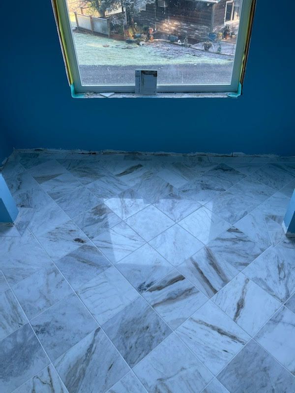 Blue room with marble tiled floor and window.
