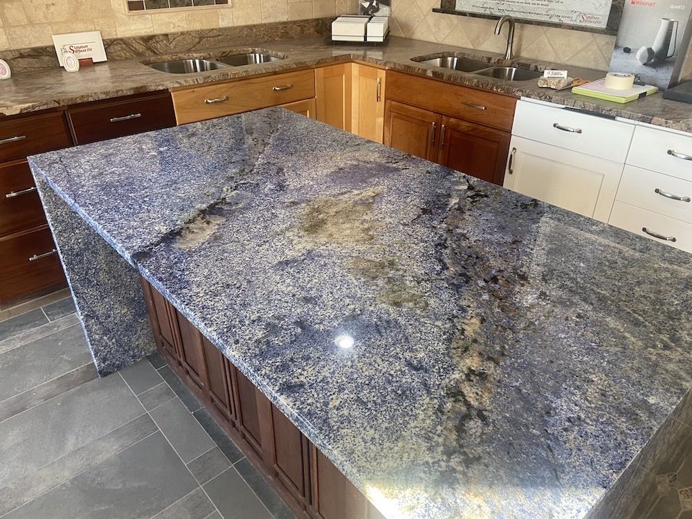 Kitchen display with a blue granite countertop island and various cabinet styles.
