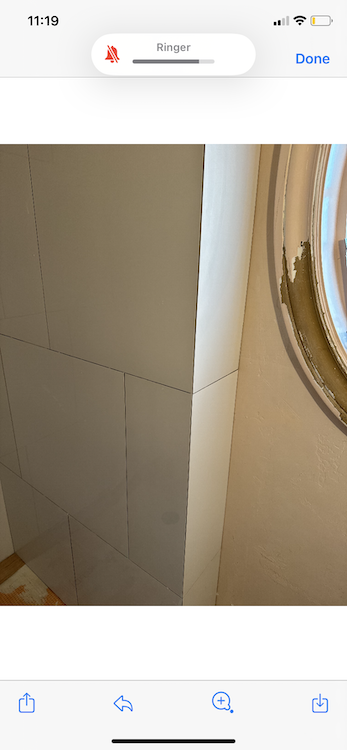 White walls with visible grout lines and a gold-rimmed mirror.