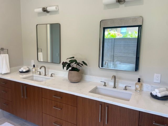 Modern bathroom with double vanity, rectangular mirrors, and brown cabinets.