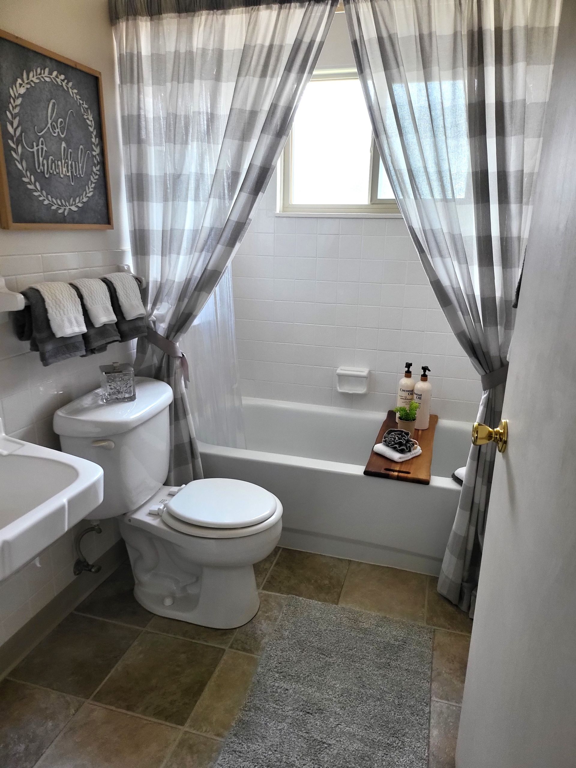 A bathroom with a toilet , sink , bathtub and shower curtain.