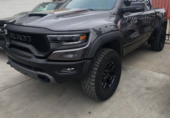 Dark gray Ram TRX truck parked outside. Black wheels, tires, fender flares.