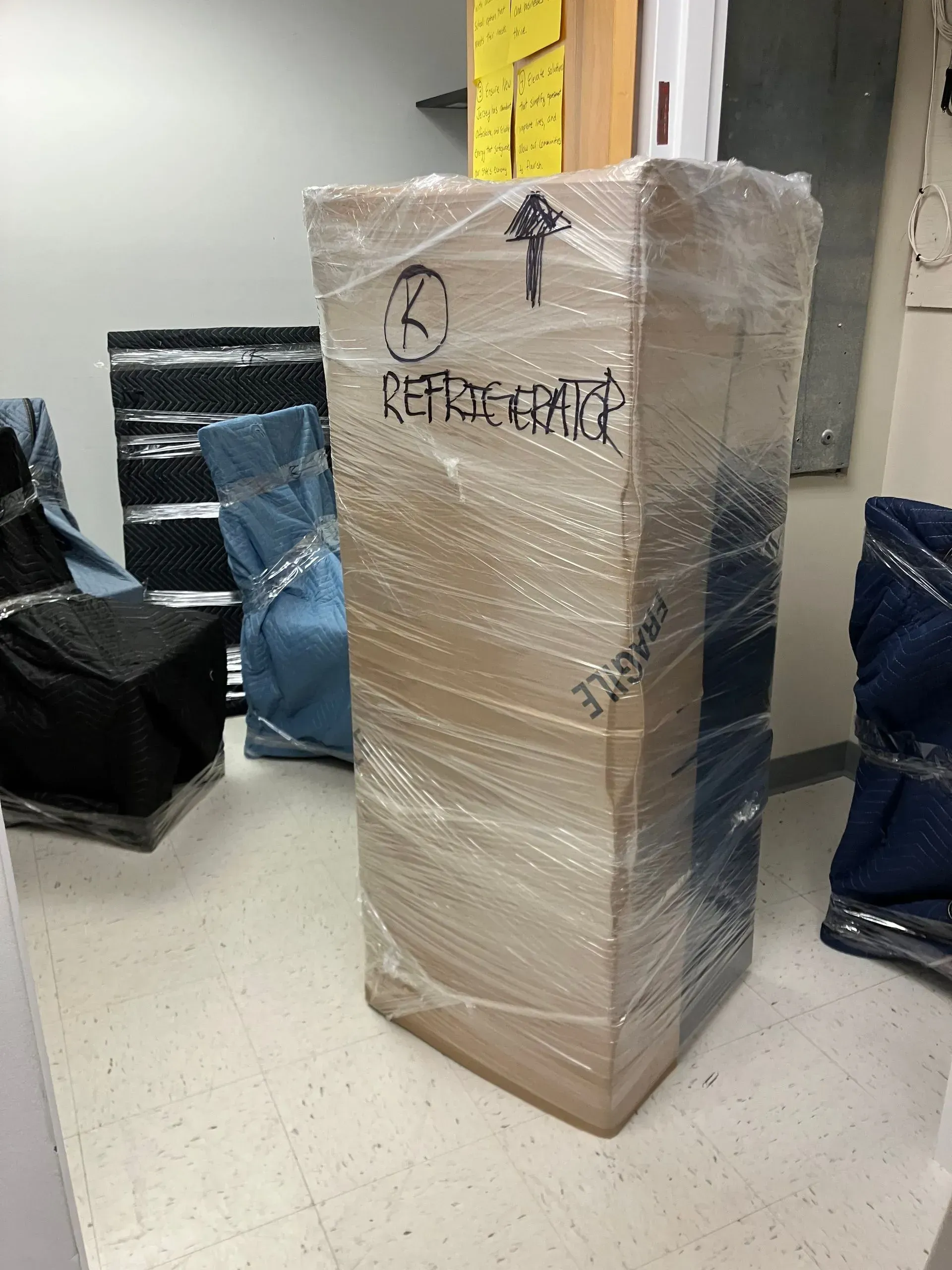 Cardboard box wrapped in plastic, labeled 