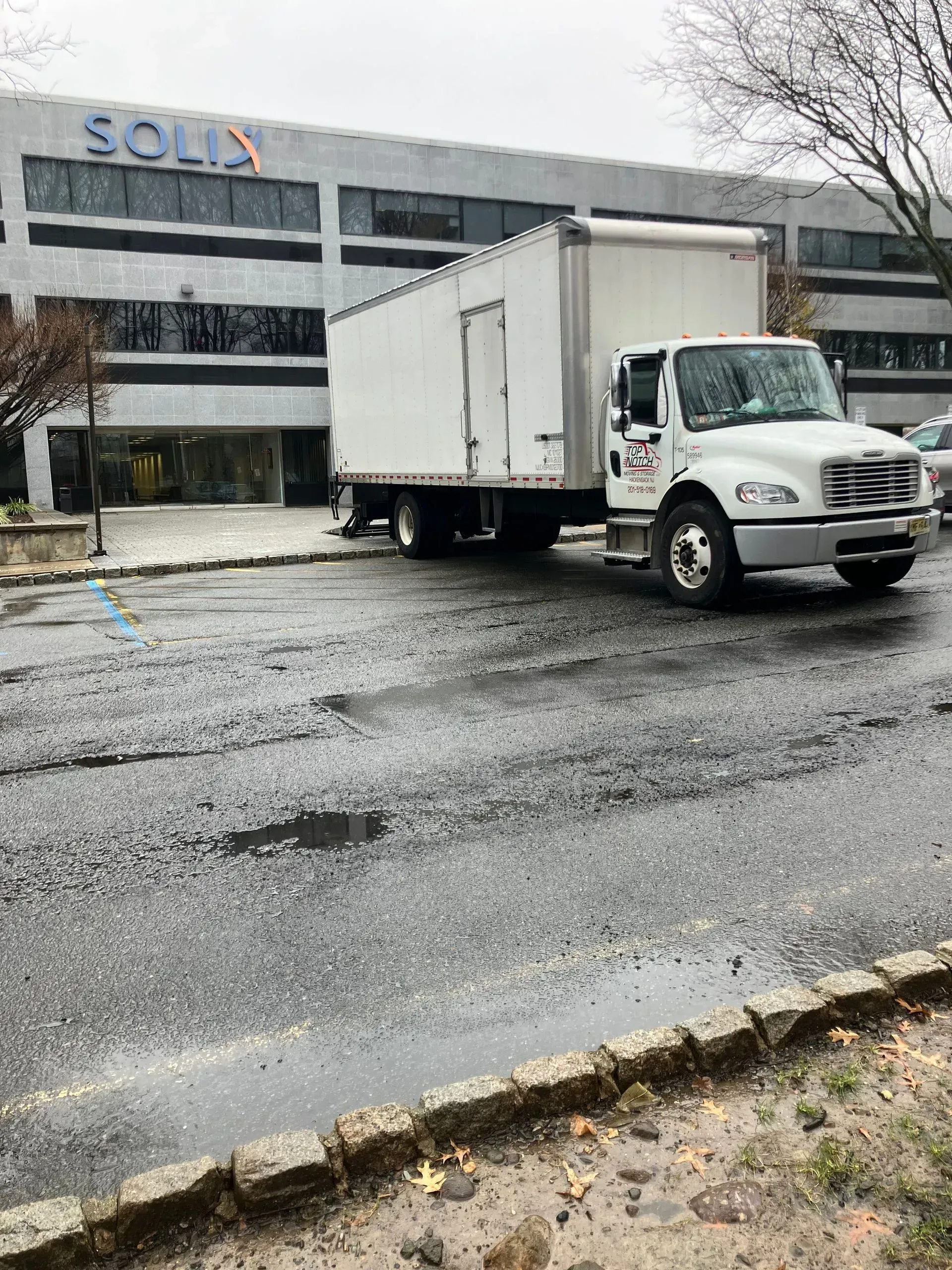 Box truck parked near a building with 