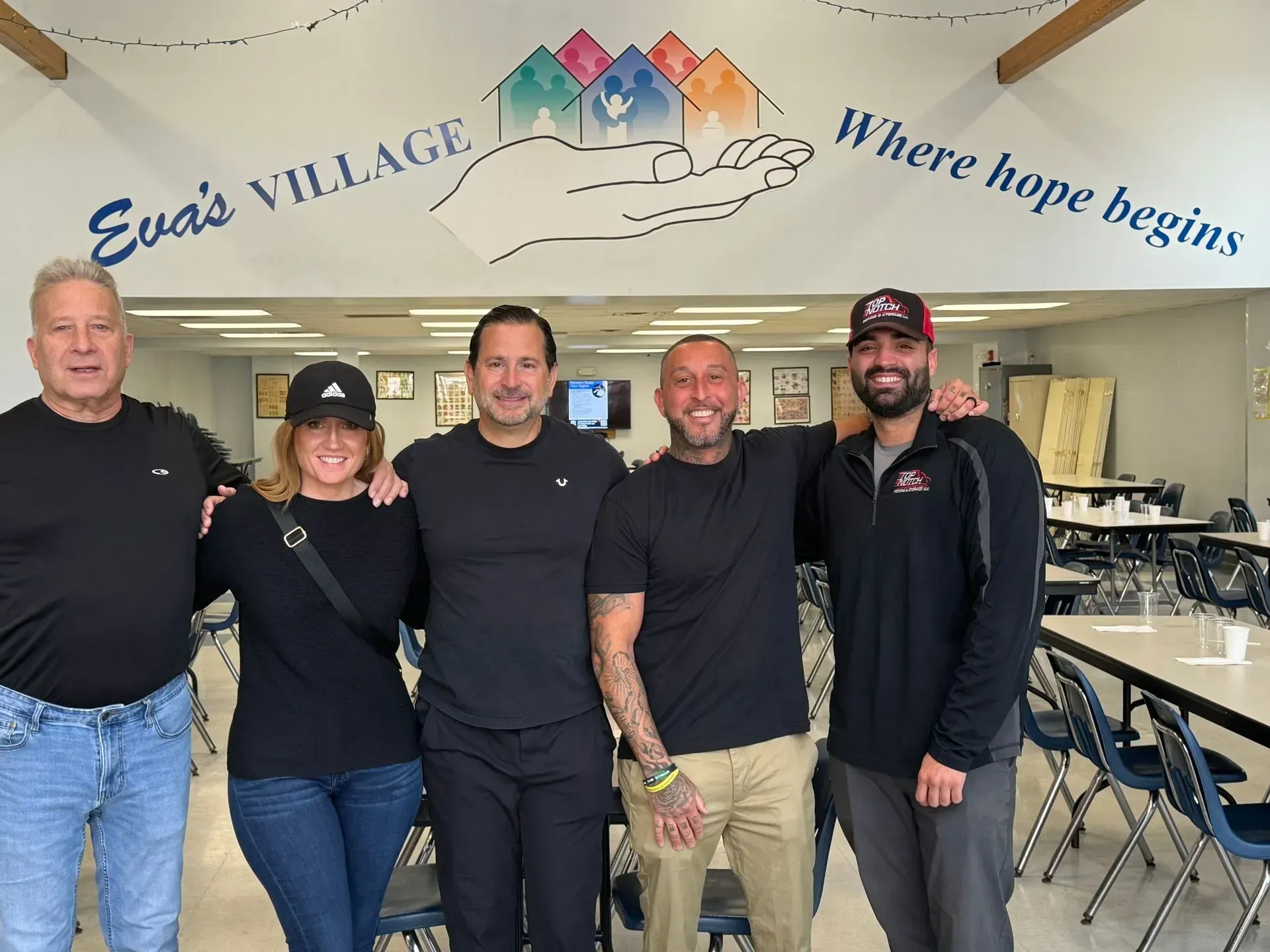 Five people standing together in front of 