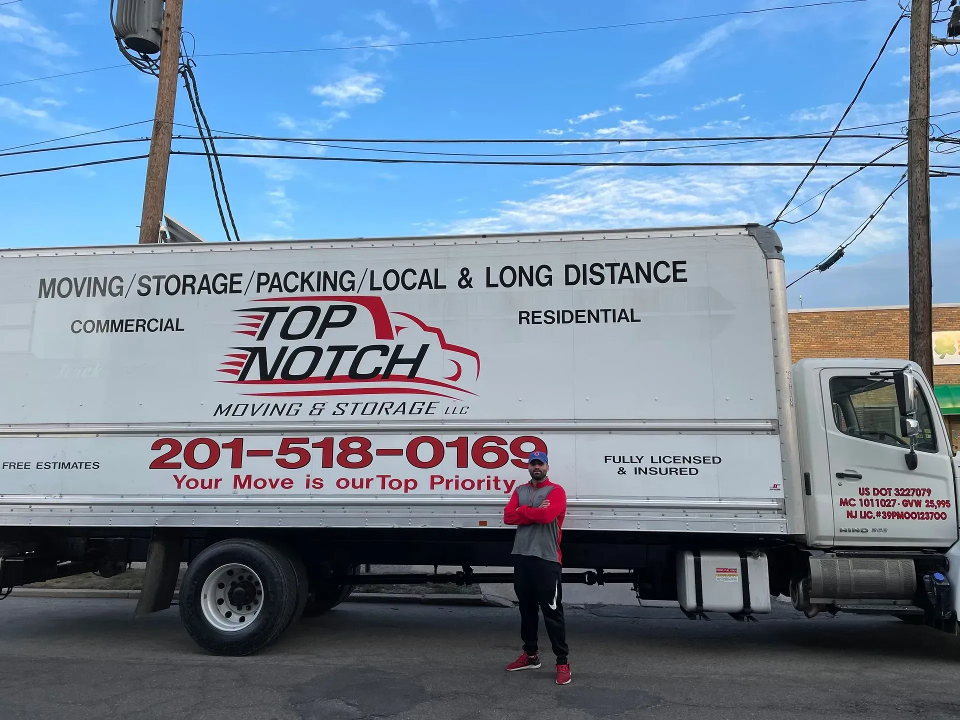 Man standing next to a moving truck labeled 