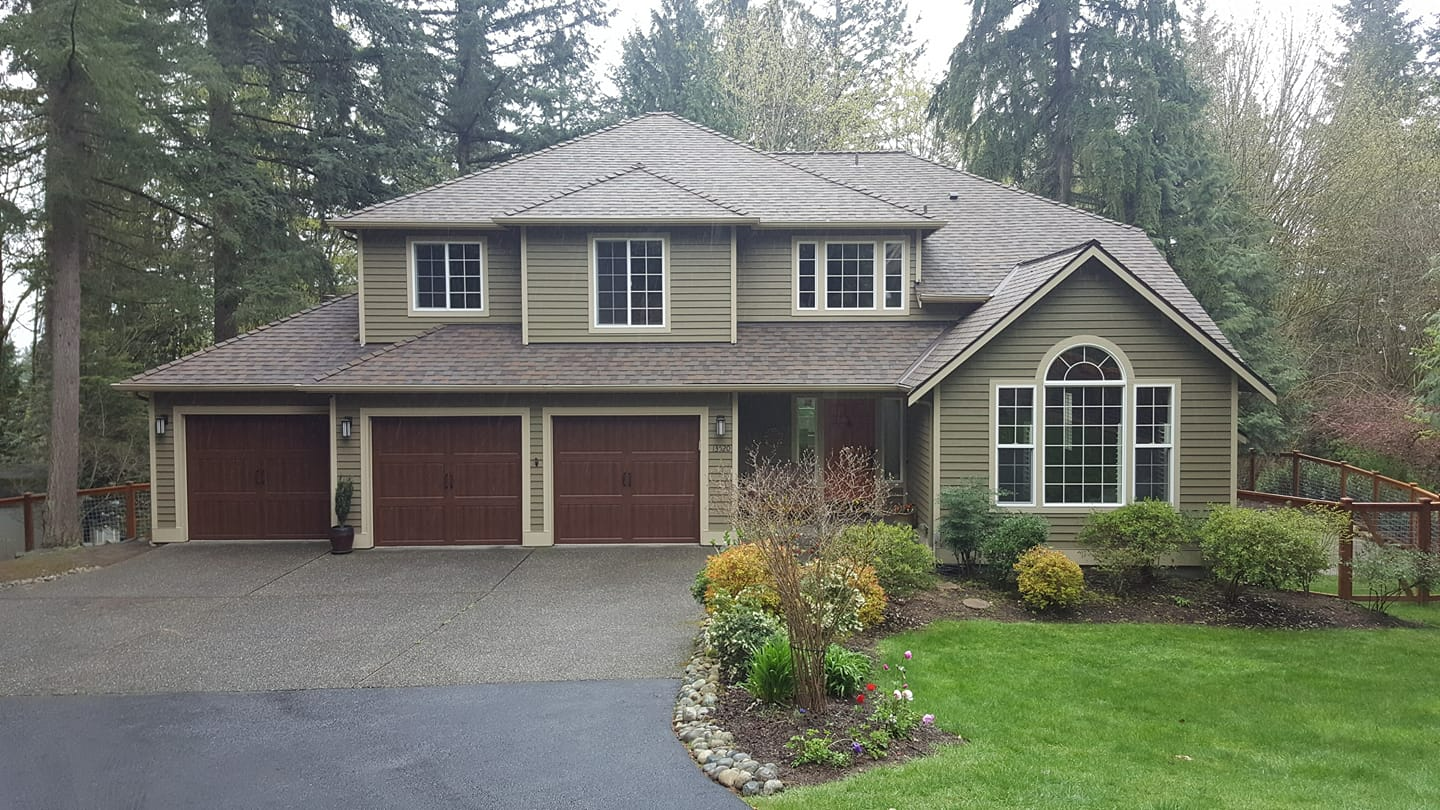 a large house with three garage doors and a driveway
