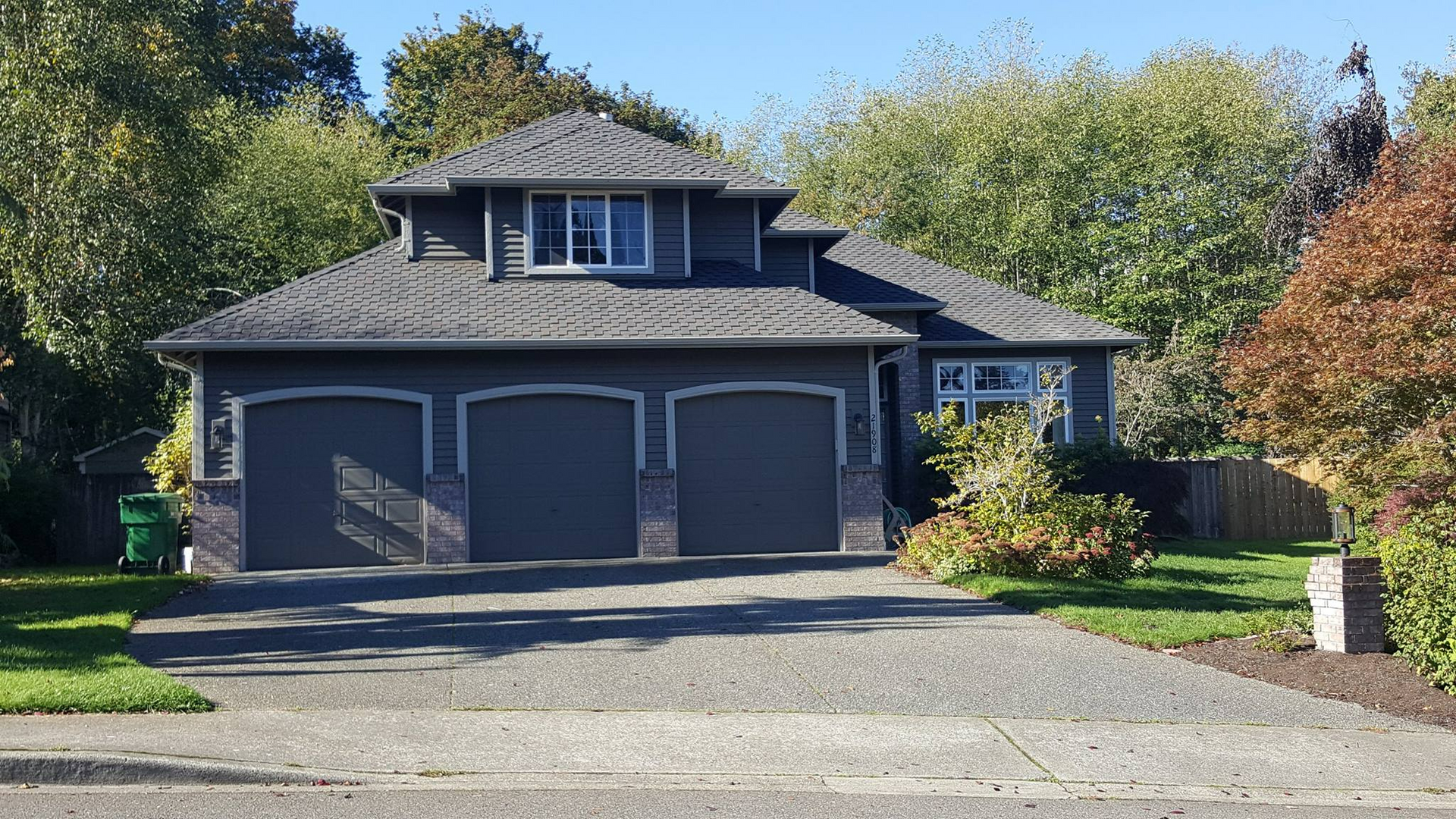 a large house with two garages and a driveway in front of it .