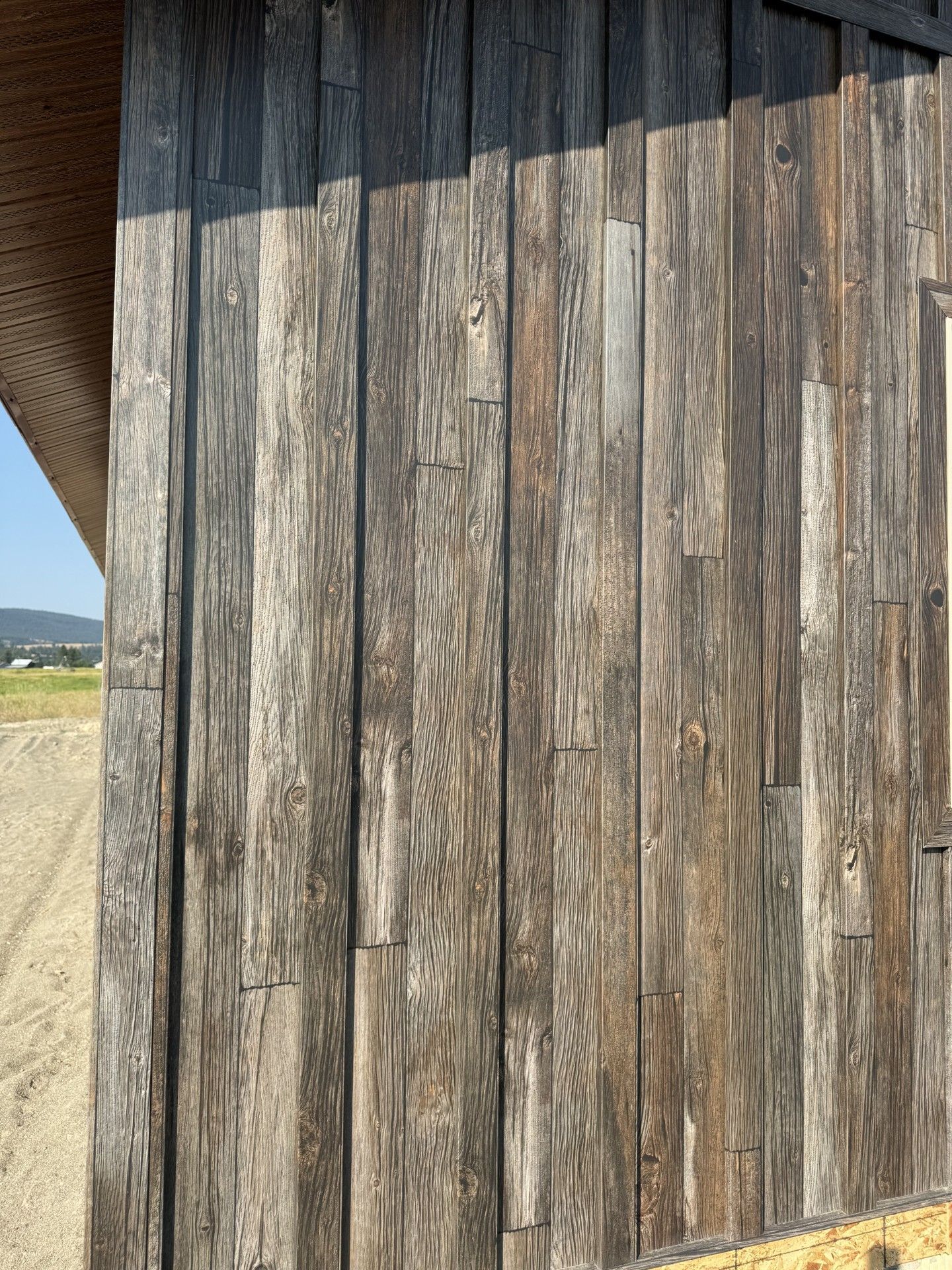 A wooden wall with a brick building in the background