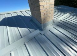 A metal roof with a chimney on top of it