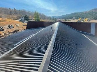 A close up of a roof with a mountain in the background.