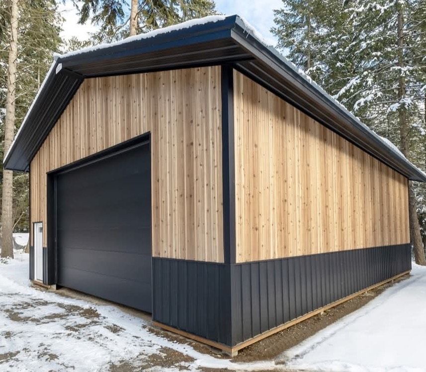 A garage with a black door and wooden siding