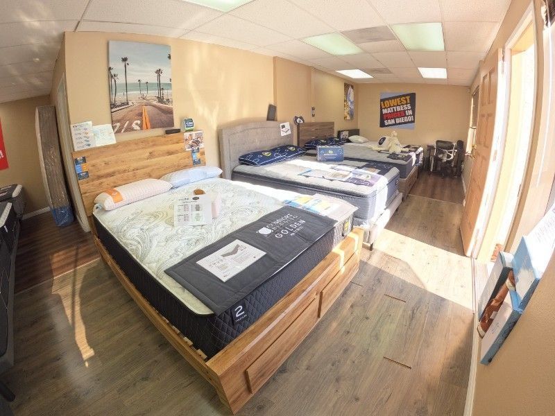 A room with a lot of beds and mattresses in it.