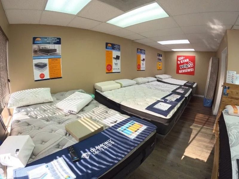 A room filled with mattresses and pillows in a store.