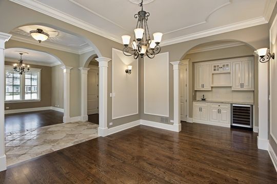 a room with a chandelier and hardwood floor