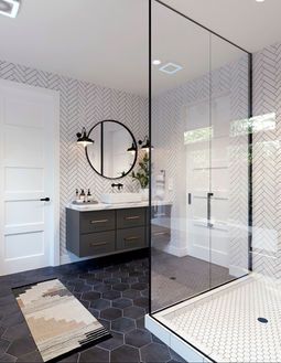 Modern bathroom with glass shower, black vanity, round mirror, and patterned floor tiles