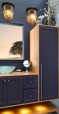 Modern bathroom vanity with dark cabinets, wood accents, illuminated mirror, and wall sconces