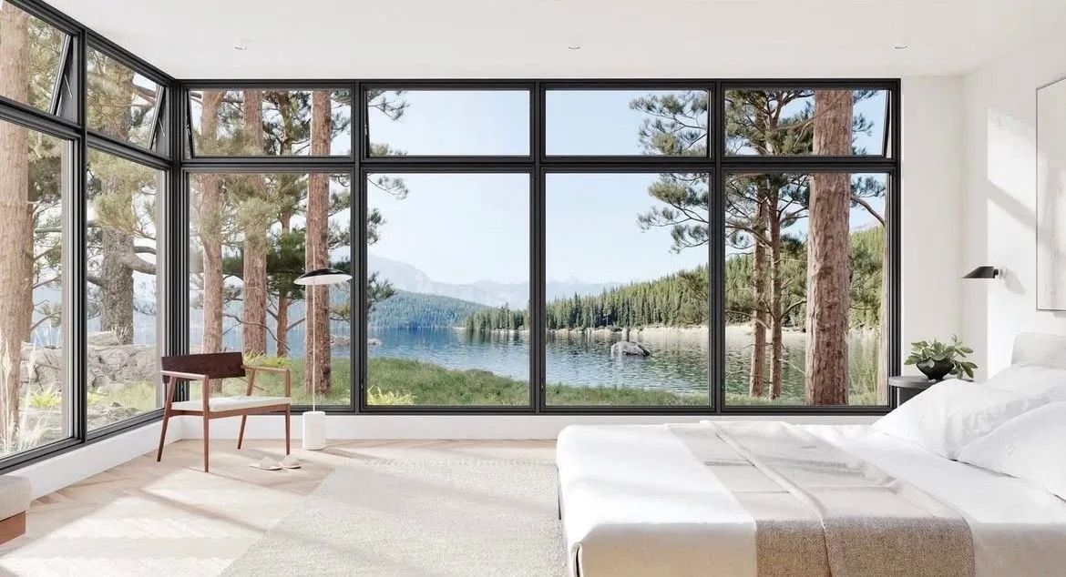 Bright modern bedroom with floor-to-ceiling windows overlooking a lake and pine trees