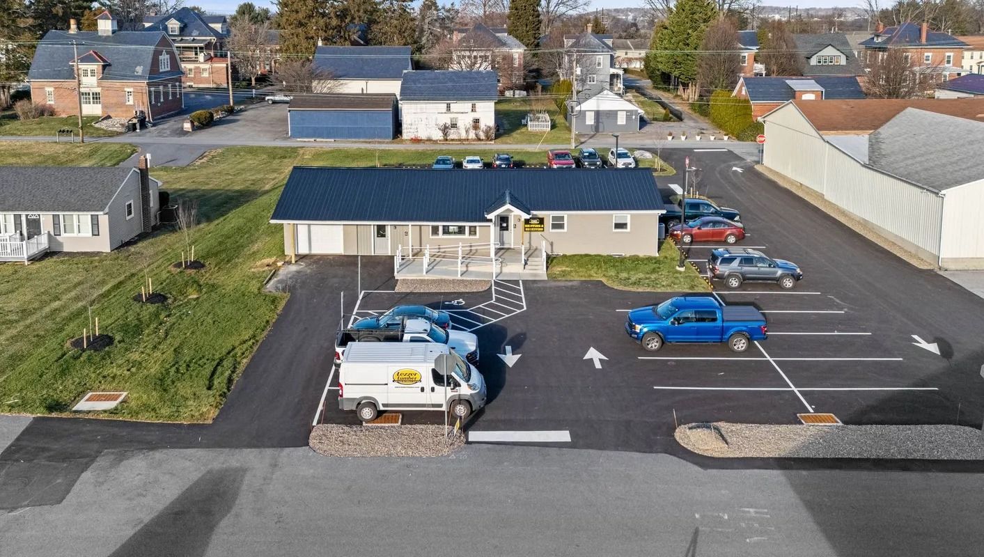 Aerial view of a small parking lot beside a single-story building with several parked cars.