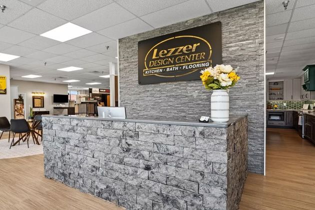 Modern reception with stone counter and gray walls.
