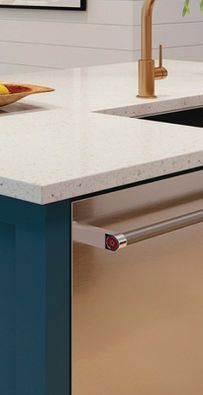 Modern kitchen counter with white countertop, copper faucet, and blue cabinet drawer handle