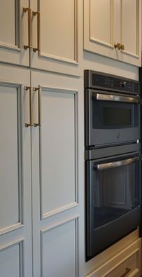 Built-in stainless steel double wall oven beside cream kitchen cabinets