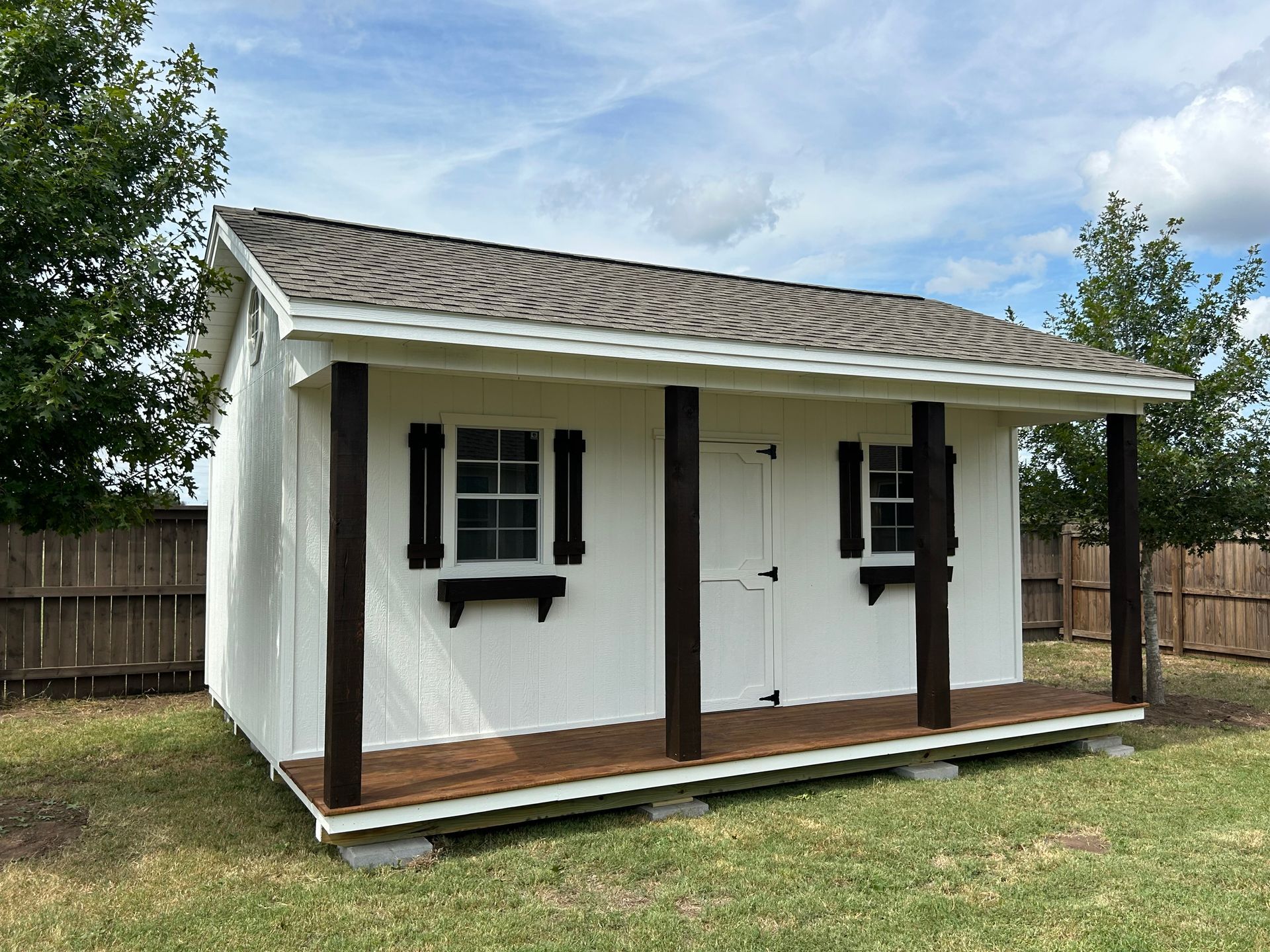 A cottage-style shed with porch