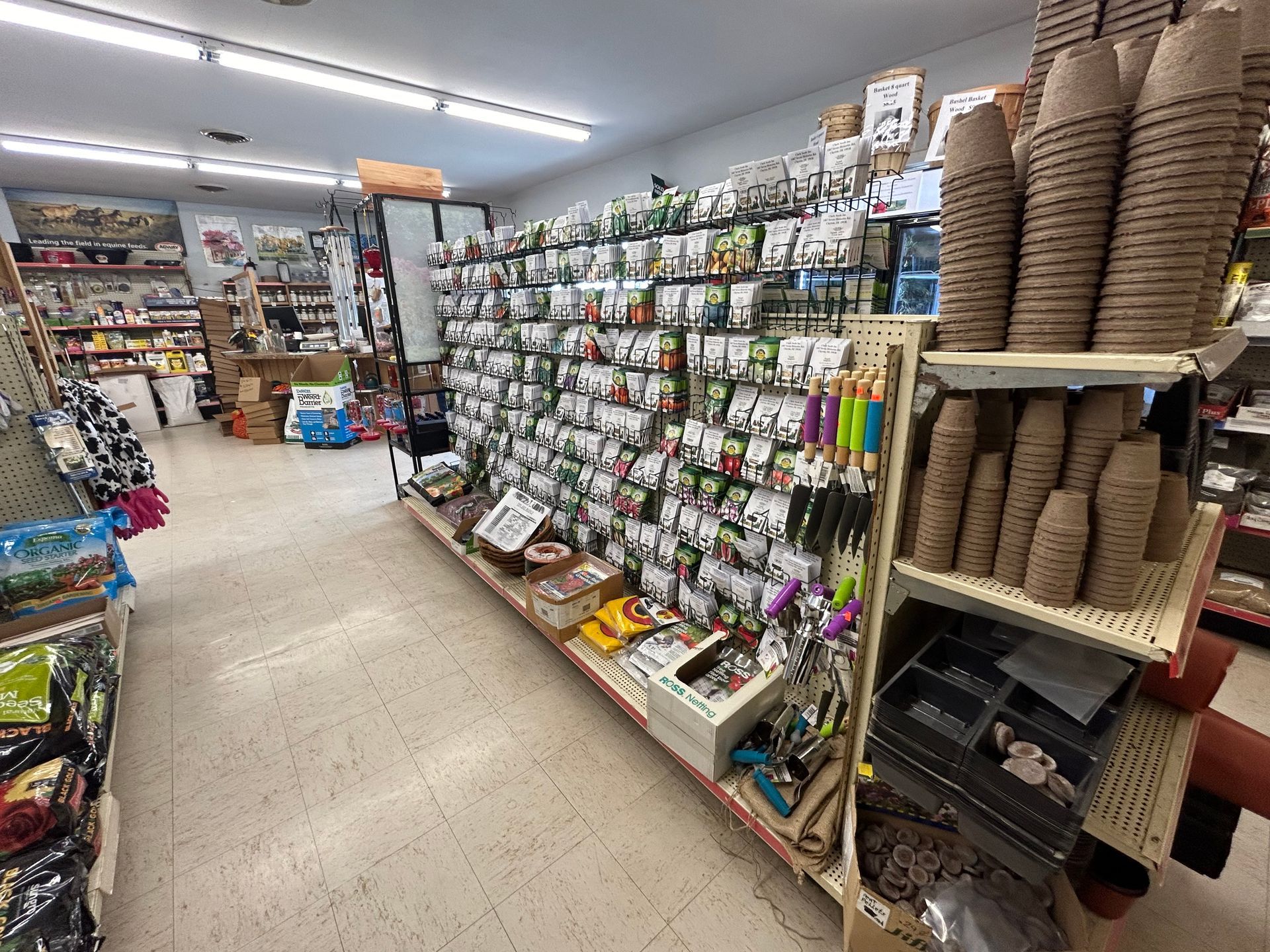 A store aisle filled with lots of plants and pots