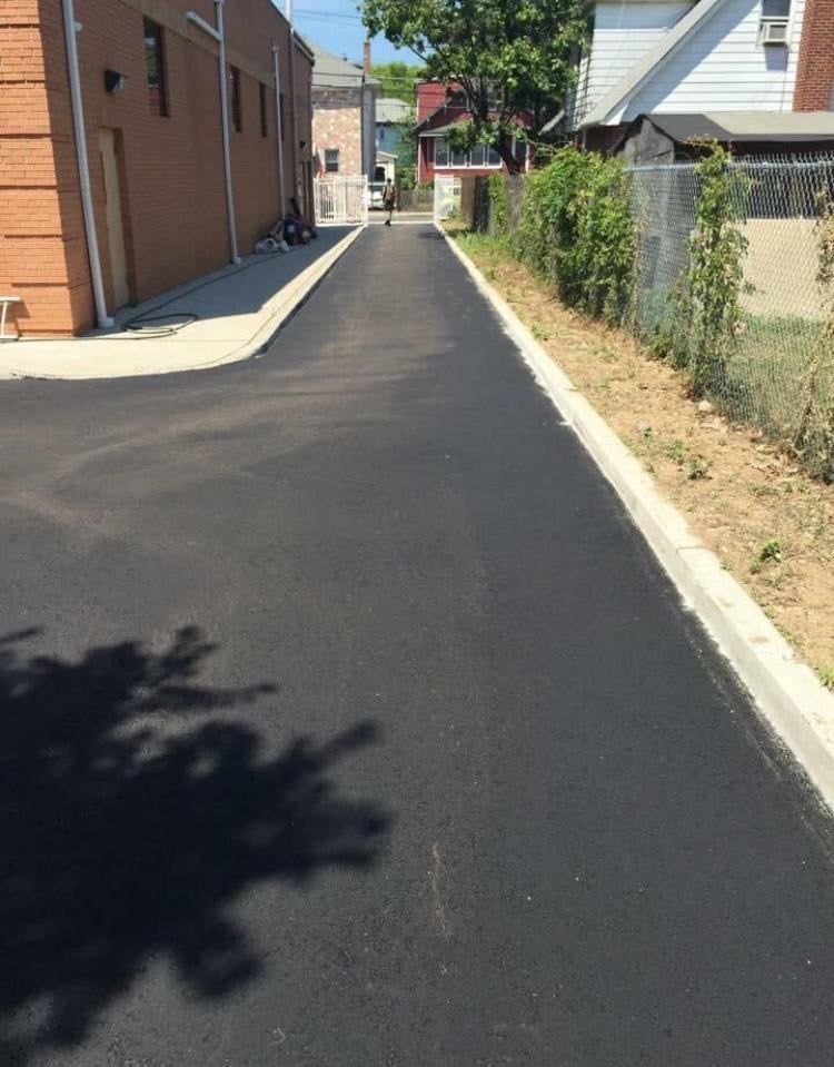 A shadow of a tree is cast on the side of a road