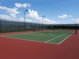 A tennis court with a fence around it on a sunny day
