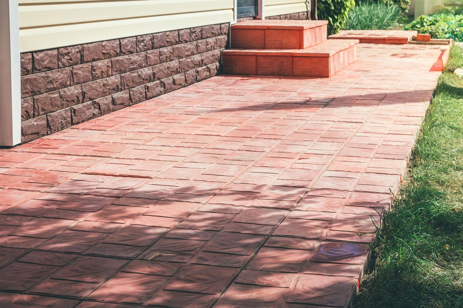 A brick walkway with stairs leading up to a house.